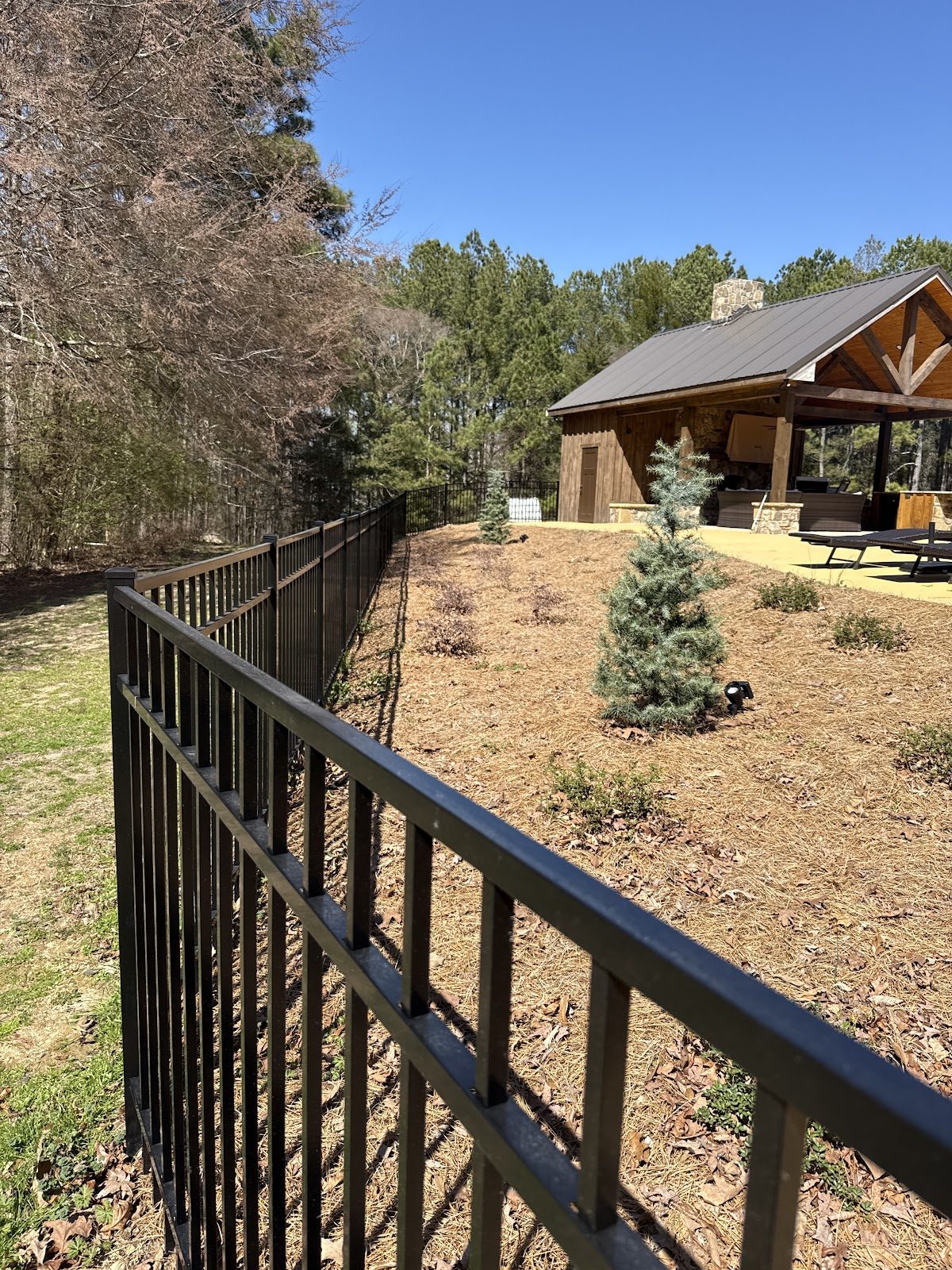 Black metal fence with landscaping