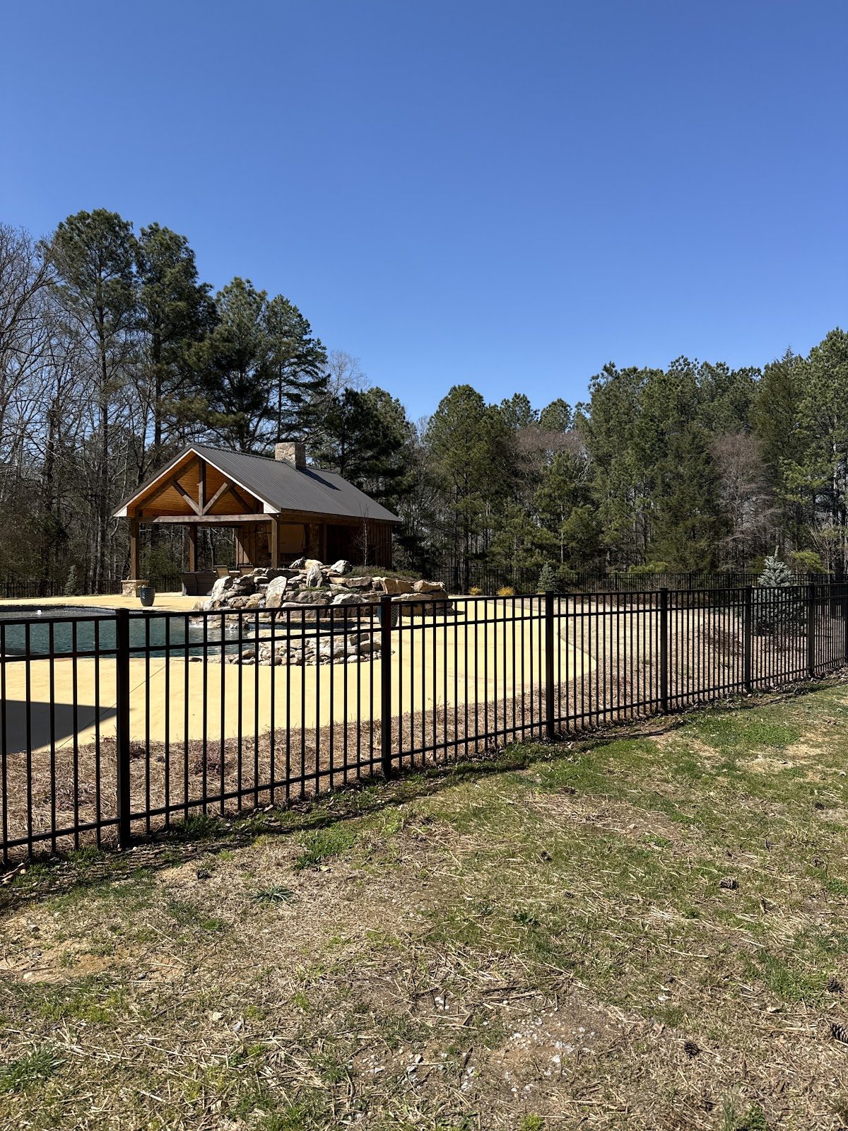 Black metal fence around a backyard pavilion